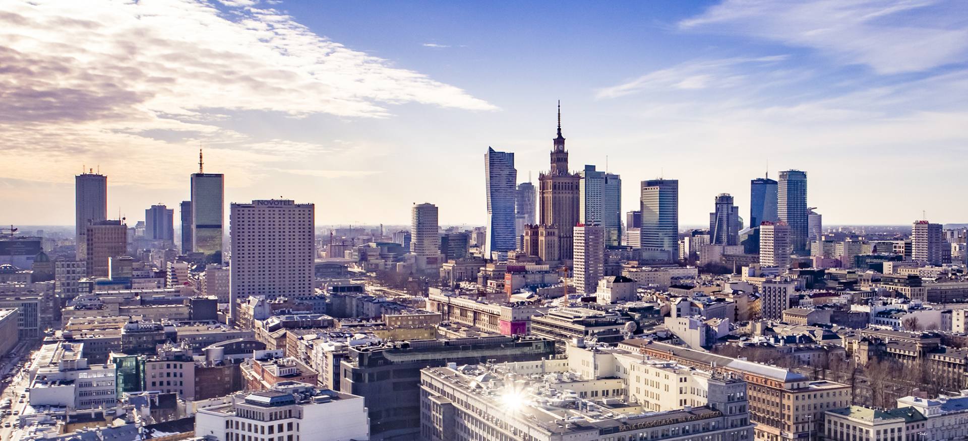 Panorama Warszawy z widocznym Pałacem Kultury i Nauki w słoneczny dzień.